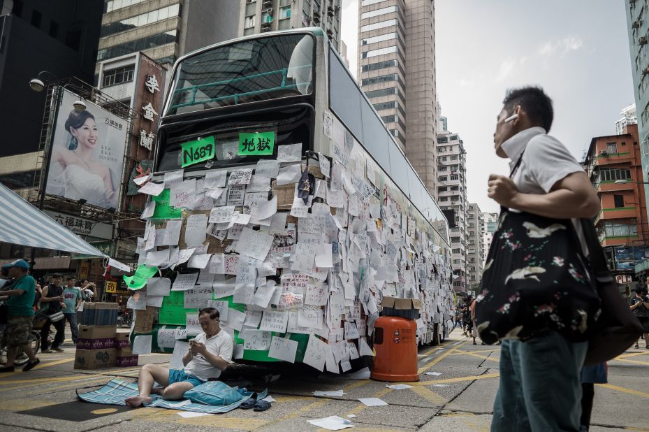 A pro-democracy demonstrator guards a bus covered with messages of support in Hong Kong on September 30.