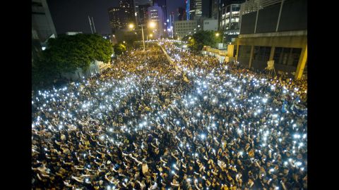 Protesters hold up their cell phones in a display of solidarity during a protest outside the Legislative Council headquarters in Hong Kong on Monday, September 29.
