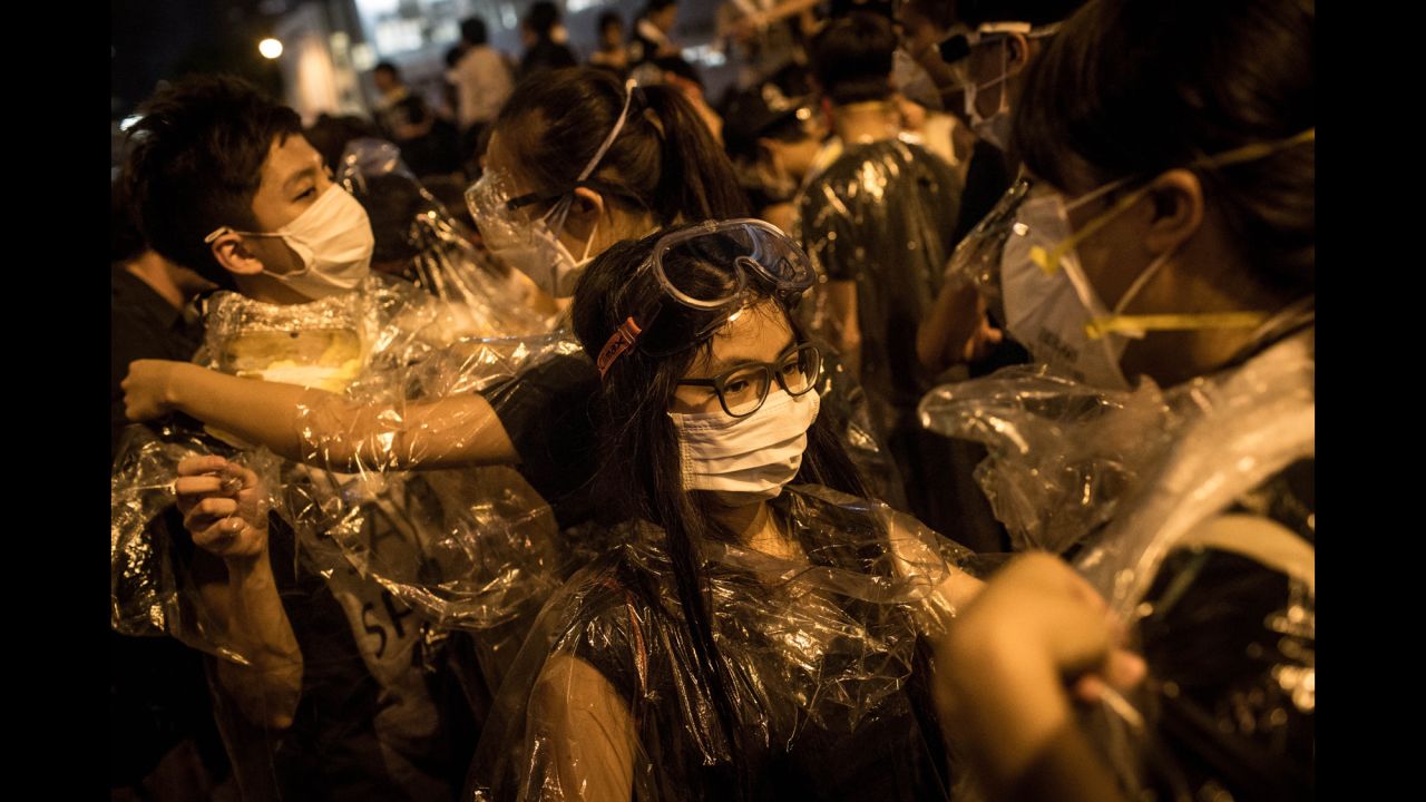 Protesters put on goggles and wrap themselves in plastic on September 29 after hearing a rumor that police were coming with tear gas.