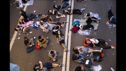 Protesters sleep on the streets outside the Hong Kong Government Complex at sunrise on September 30.