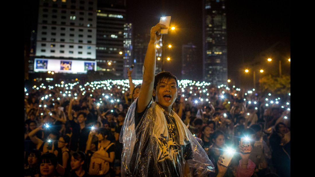 Protesters sing songs and wave their cell phones in the air after a massive thunderstorm passed over the Hong Kong Government Complex on September 30.