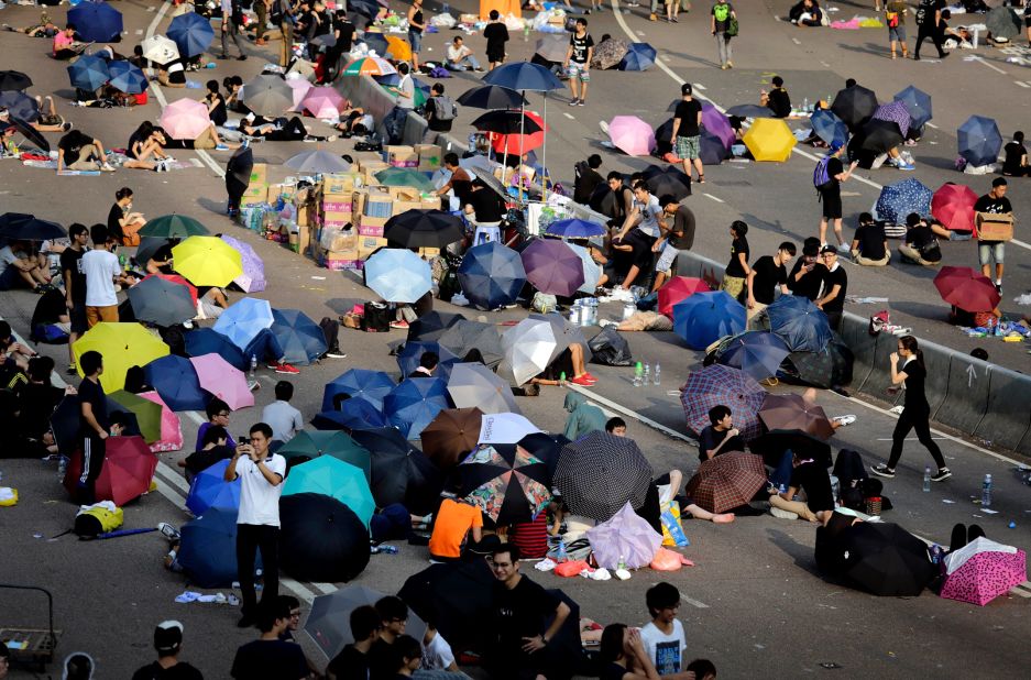 In daylight, umbrellas provide shade for pro-democracy activists. Students and activists rest on the street as they camp out in the main road in Hong Kong. 