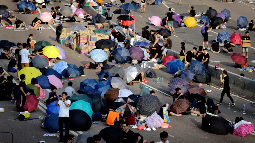 Student activists sleep on a road, many under the shade of umbrellas, near the government headquarters where pro-democracy activists have gathered and made camp, Tuesday, Sept. 30, 2014, in Hong Kong. Students and activists, many of whom have been camped out since late Friday, spent a peaceful night singing as they blocked streets in Hong Kong in an unprecedented show of civil disobedience to push demands for genuine democratic reforms. (AP Photo/Wong Maye-E)