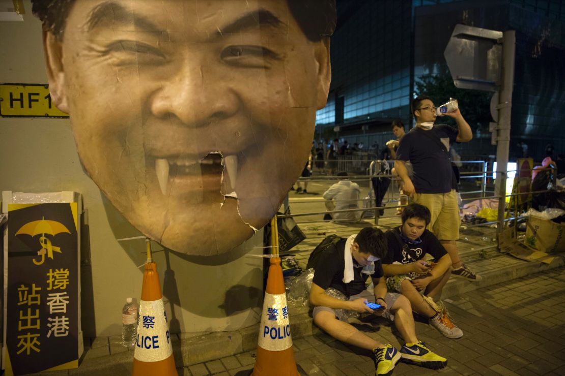 Groups of protesters gather outside the Hong Kong Government Complex in front of a poster mocking C.Y. Leung, Hong Kong's Chief Executive on September 30.