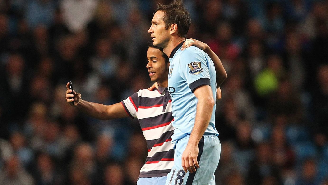A young fan grabs a selfie with Manchester City's Frank Lampard after running onto the field during the English soccer club's match against Sheffield Wednesday on Wednesday, September 24. The fan was arrested.