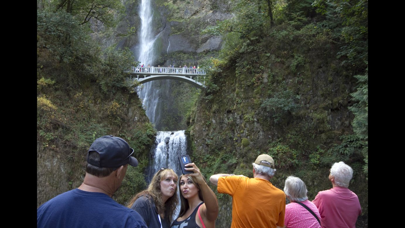 Visitors take a selfie in front of Oregon's Multnomah Falls on Friday, September 26.