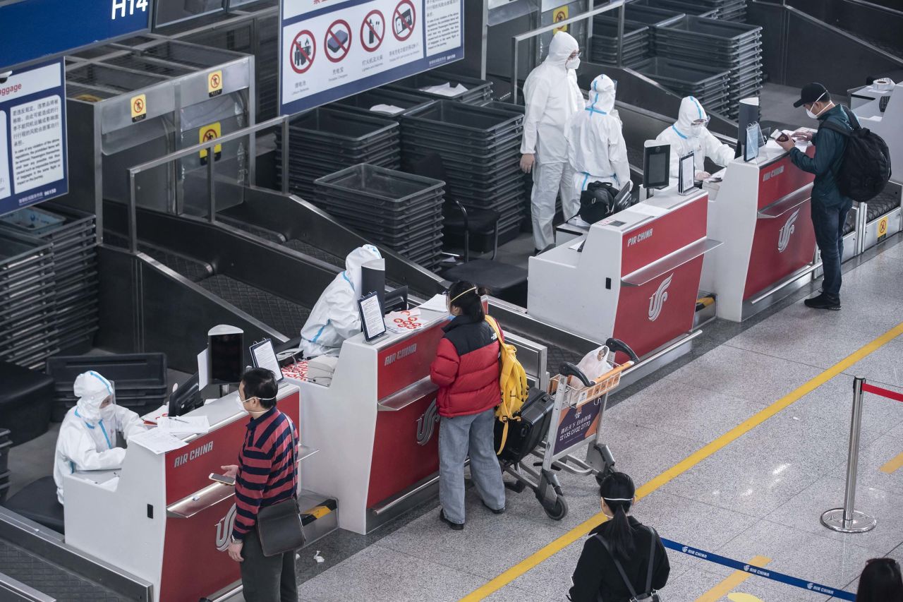 Airport employees assist inbound passengers transferring at Capital International Airport in Beijing, China, on March 18.