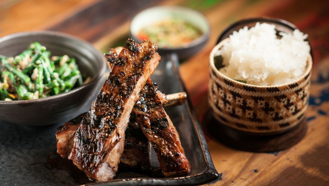 New York City restaurant Khe-Yo serves Laotian-inspired Southeast Asian cuisine. On the dinner menu: Berkshire spare ribs (ping sien moo) with sticky rice and a long bean and cherry tomato salad. 