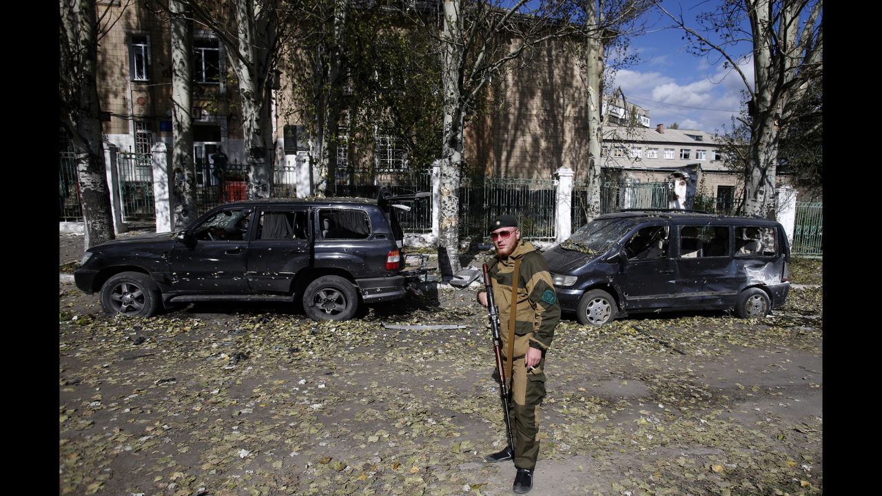 A pro-Russian rebel guards a damaged school in Donetsk on October 1.