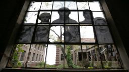 Images that are part of the exhibit "Unframed -- Ellis Island" by artist JR are incorporated into a dilapidated window inside the contagious diseases ward of the Ellis Island hospital complex, Thursday, Sept. 25, 2014, in New York. The complex, which will be opened to the public for the first time ever on Oct. 1, 2014, stopped operating in 1954. In its day, the complex was the largest U.S. Public Health Service institution. Sick and pregnant immigrants were treated and cured before they were allowed to enter the country _ or were sent back to their native land. The facility included wards for contagious diseases, mental health and obstetrics. (AP Photo/Julio Cortez)