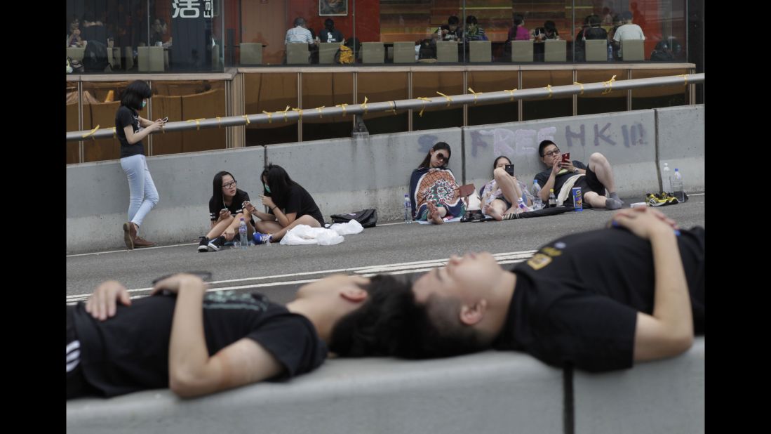 Pro-democracy demonstrators sleep on the street outside a government complex in Hong Kong on Thursday, October 2.