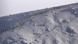 Rescuers walk in line after their search operation near the peak of Mount Ontake in central Japan on Wednesday, October 1.
