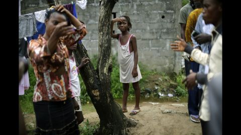 A girl cries as community activists approach her outside her Monrovia home on October 2, 2014, a day after her mother was taken to an Ebola ward.