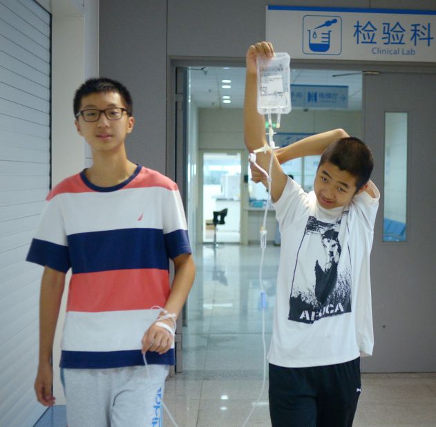 Patients are often processed at speed in the public health system. In this picture, a relative helps a patient with his intravenous drip.