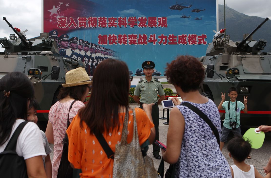 Visitors take photographs with PLA personnel during an open day at their barracks in Hong Kong in June.