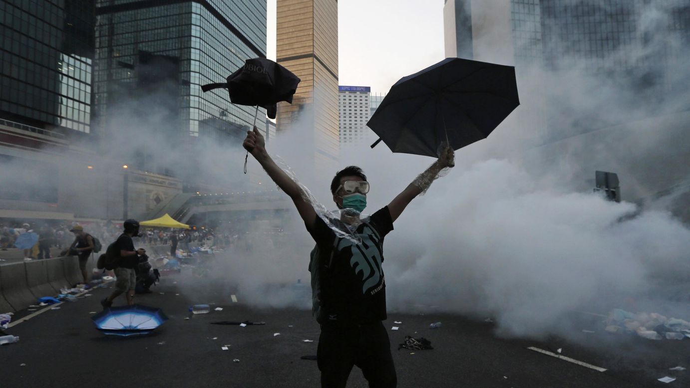 A pro-democracy demonstrator raises umbrellas as tear gas is fired by police outside the government headquarters in Hong Kong on Sunday, September 28. <a href="http://www.cnn.com/2014/09/22/asia/gallery/hong-kong-students-protest/index.html">Demonstrators are angry</a> at China's decision to allow only Beijing-vetted candidates to run in the city's elections for chief executive in 2017. They say Beijing has gone back on its pledge to allow universal suffrage in Hong Kong, which was promised "a high degree of autonomy" when it was handed back to China in 1997.