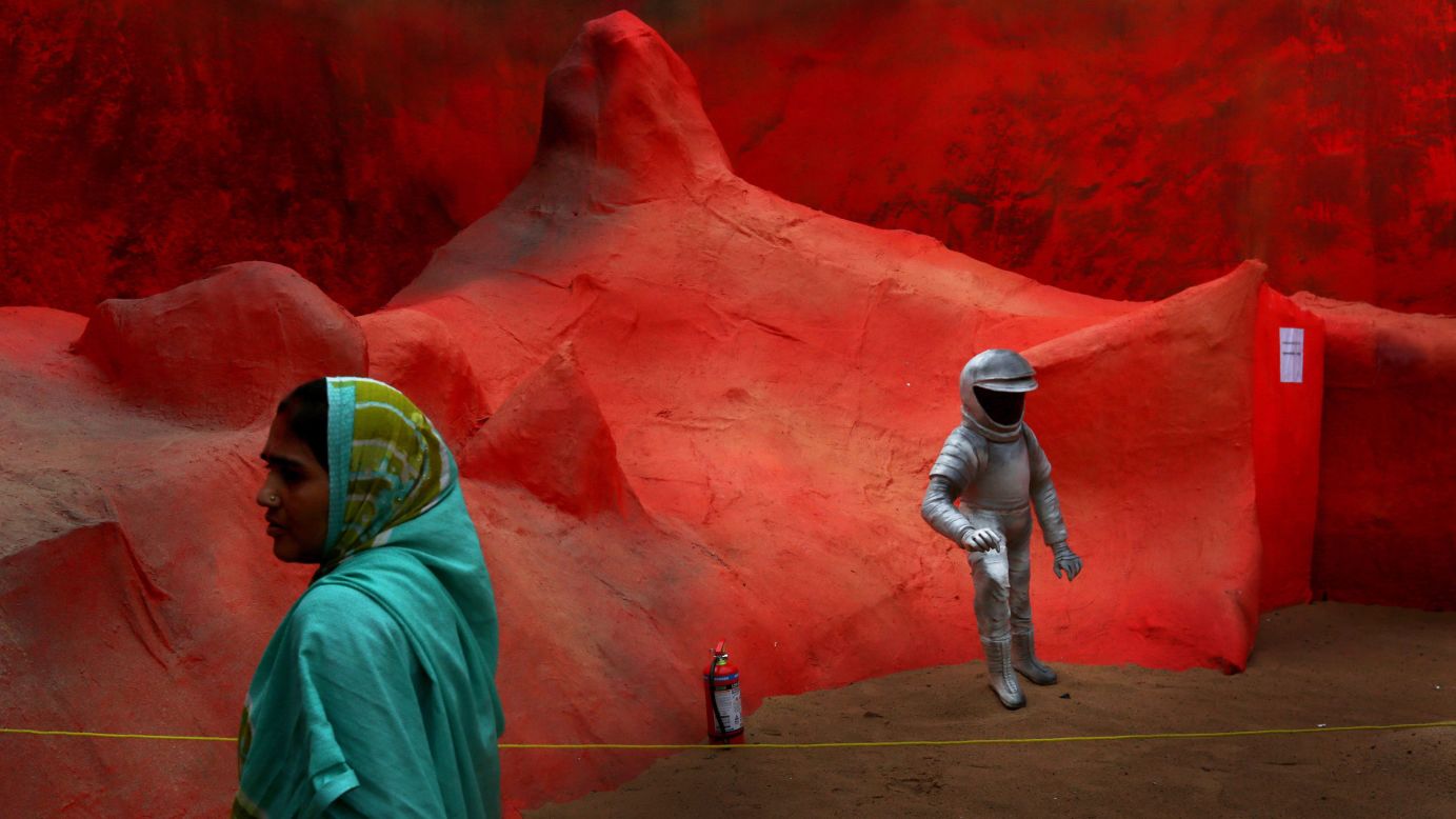 A woman walks by an art installation called Mars Mission on Tuesday, September 30, during the Durga Puja festival in Kolkata, India. India's <a href="http://www.cnn.com/2014/09/23/world/asia/mars-india-orbiter/">Mars Orbiter Mission</a> successfully entered Mars' orbit last month.
