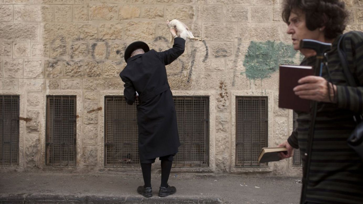 An ultra-Orthodox Jewish man performs the Kaparot ceremony in Jerusalem on Thursday, October 2. It is believed that the Jewish ritual, which involves swinging a live chicken above one's head, transfers the sins of the past year to the chicken, which is then slaughtered and traditionally given to the poor. The ritual is performed before Yom Kippur, the most important day in the Jewish calendar.