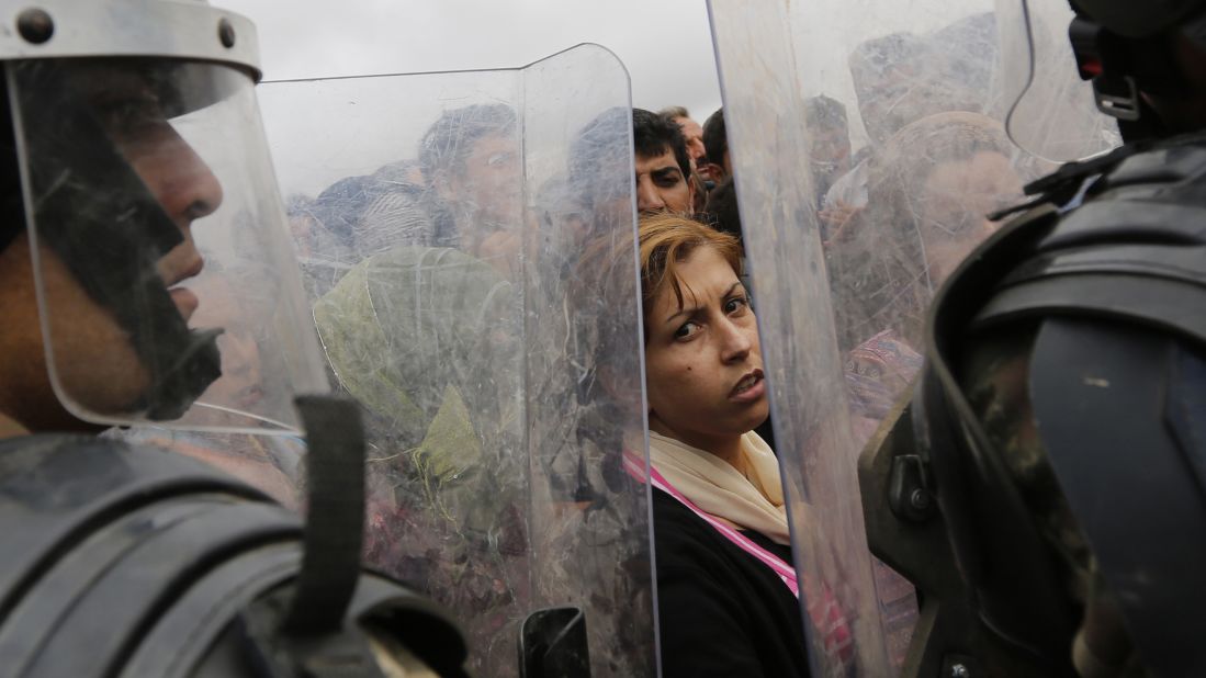 Syrian Kurds wait near a border crossing in Suruc as they wait to return to their homes in Kobani on Sunday, September 28.