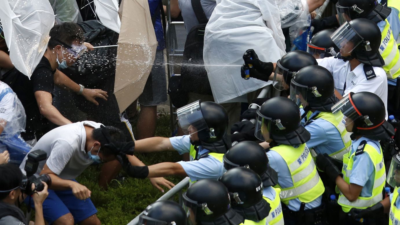 Riot police use pepper spray as they clash with protesters outside the government headquarters in Hong Kong on Tuesday, September 28.