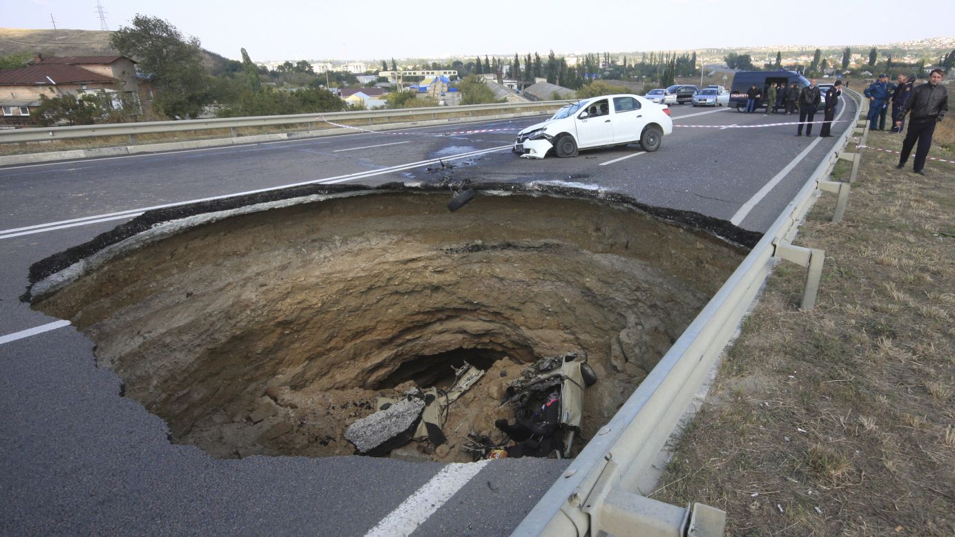 A car lies in a sinkhole outside Simferopol, Crimea, on Sunday, September 28. Six people were killed, according to local media.