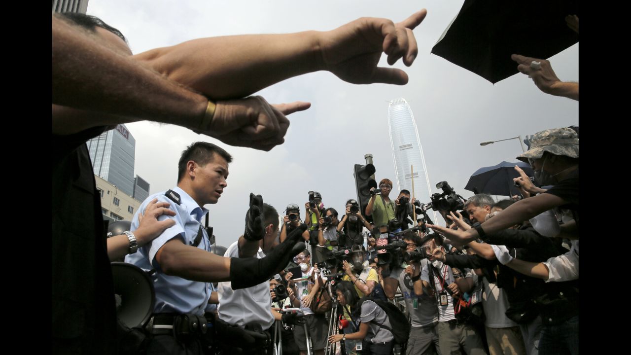 Police raise hands against protesters as an ambulance tries to leave the compound of the chief executive office in Hong Kong on October 3.  