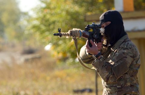 An Ukrainian sniper aims his weapon at a checkpoint near Popasna, Ukraine, on Thursday, October 2. 