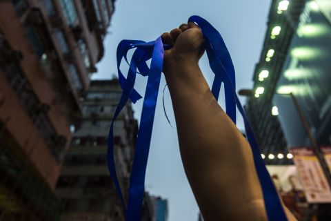 A pro-Beijing activist holds up blue ribbons for anti-Occupy Central protestors to collect as pro-government speeches are made in the Kowloon district of Hong Kong on October 4.