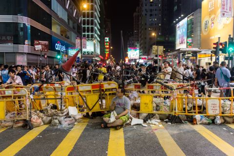 A man sits in front of a barricade built by pro-democracy protesters on October 4 in the Kowloon district.
