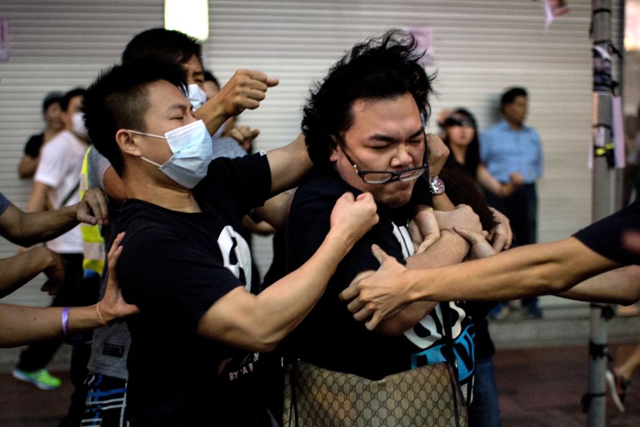 A group of men in masks fight with a man who tried to stop them from removing barricades from a pro-democracy protest area in the Causeway Bay district of Hong Kong on Friday, October 3.