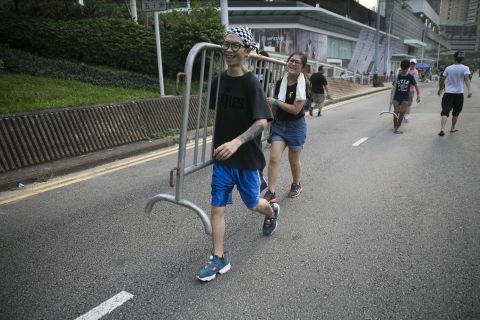 Student protesters carry a barrier to block a street leading to the protest site on October 5.