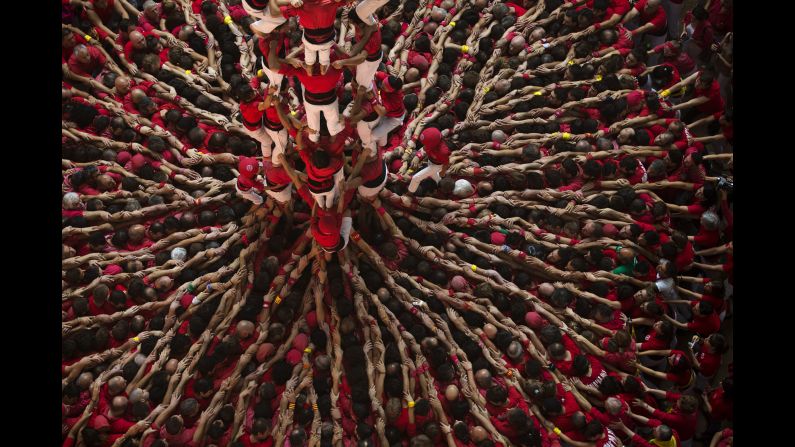 Members of the Castellers Joves Xiquets de Valls try to complete their human tower during the 25th Human Tower Competition in Tarragona, Spain, on Sunday, October 5. A "castell" is considered completely successful when it is loaded and unloaded without falling apart. 