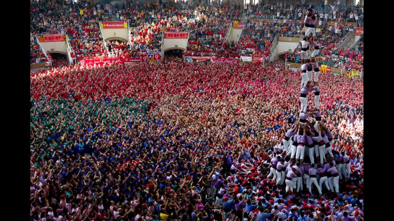 The Jove Xiquets de Tarragona form their tower as a sea of competitors look on. 