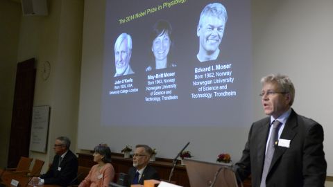 Professor Ole Kiehn, right, annouces at the Karolinska Institute in Stockholm the winners of the 2014 Nobel Prize in medicine for discoveries of cells that constitute a positioning system in the brain. Images of the winners U.S.-British scientist John O'Keefe and Norwegian husband and wife Edvard Moser and May-Britt Moser are projected on a screen at rear. 