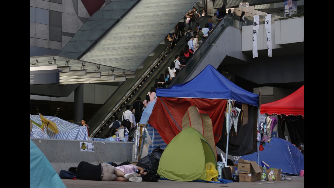 People take an escalator to work as protesters sleep on October 6.