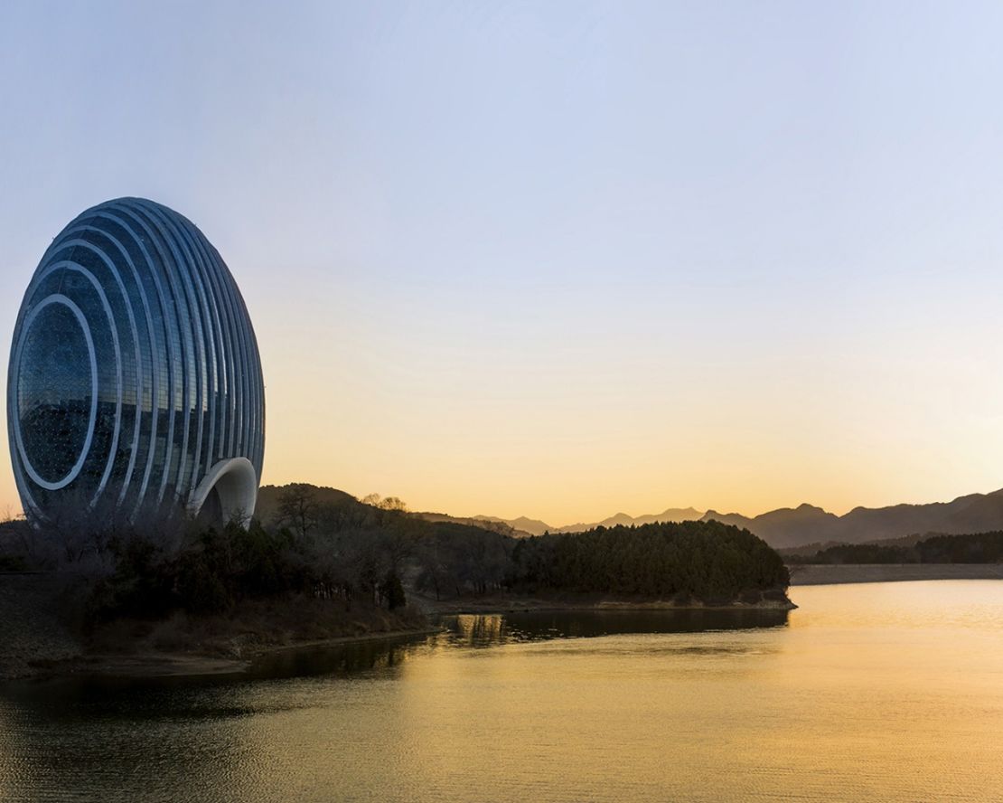 Glass panels on the Kempinski Sunrise Hotel reflect the nearby mountains, sky and lake.