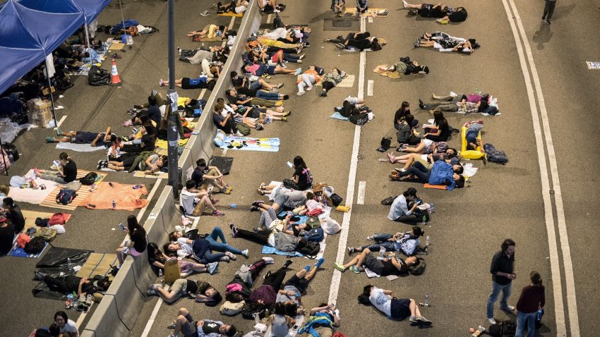 Pro-democracy protesters rest on a highway next to the central government offices in Hong Kong on October 6, 2014. Hong Kong's pro-democracy protesters remained stubbornly encamped on the streets early Monday, just hours before a government deadline to clear key thoroughfares they have blockaded for more than a week. The city's embattled leader Leung Chun-ying has warned he will 'take all necessary actions to restore social order' after a mass campaign for free elections that has seen tens of thousands of people pour onto the streets. AFP PHOTO / ALEX OGLE (Photo credit should read Alex Ogle/AFP/Getty Images)
