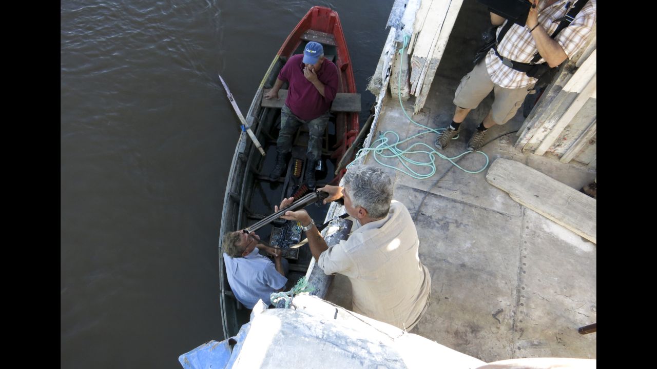 Bourdain speaks with a local fisherman who is selling shotguns along the Paraguay River.