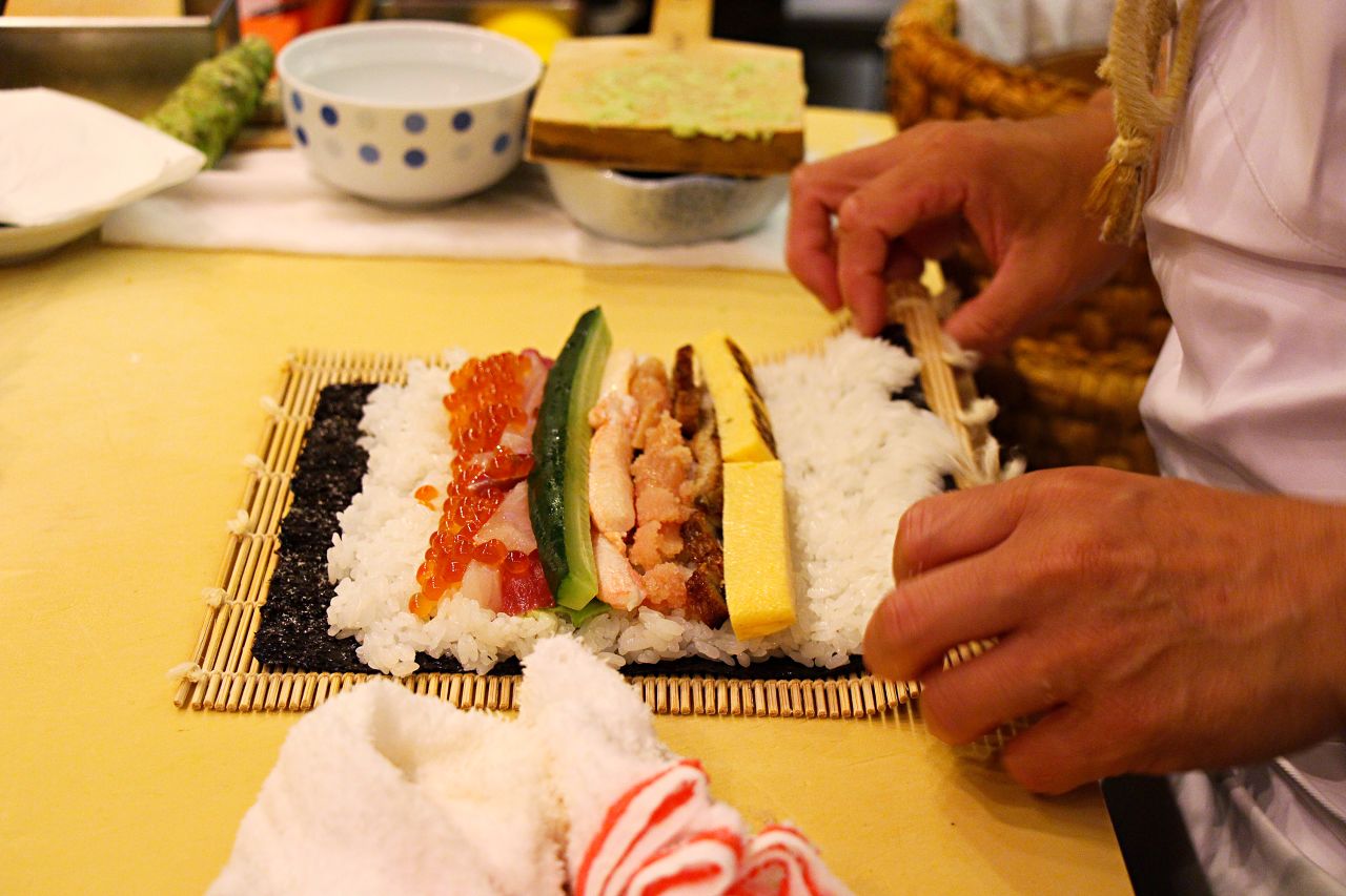 A sushi rolling mat is key. Start rolling by holding the two corners of the sea kelp.