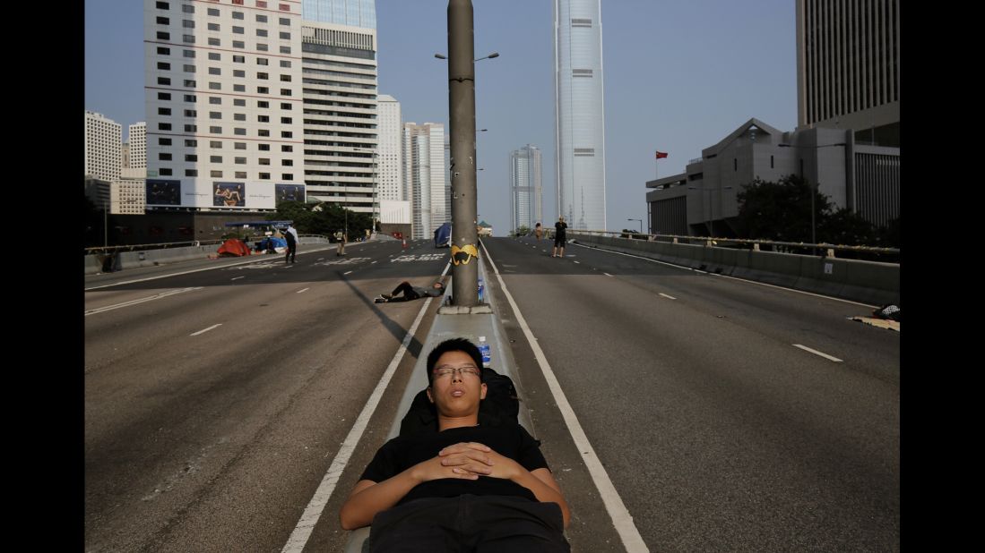 A pro-democracy protester sleeps on a street in the occupied area surrounding the government complex in Hong Kong on Wednesday, October 8. 