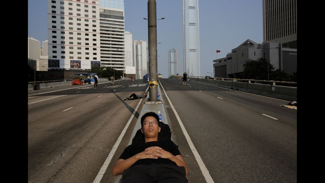 A pro-democracy protester sleeps on a street in the occupied area surrounding the government complex in Hong Kong on Wednesday, October 8.