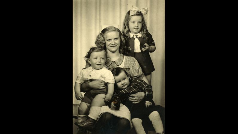 Blitzer, left, is held by his babysitter in Germany with his sister Helena and his cousin Israel Friedman.