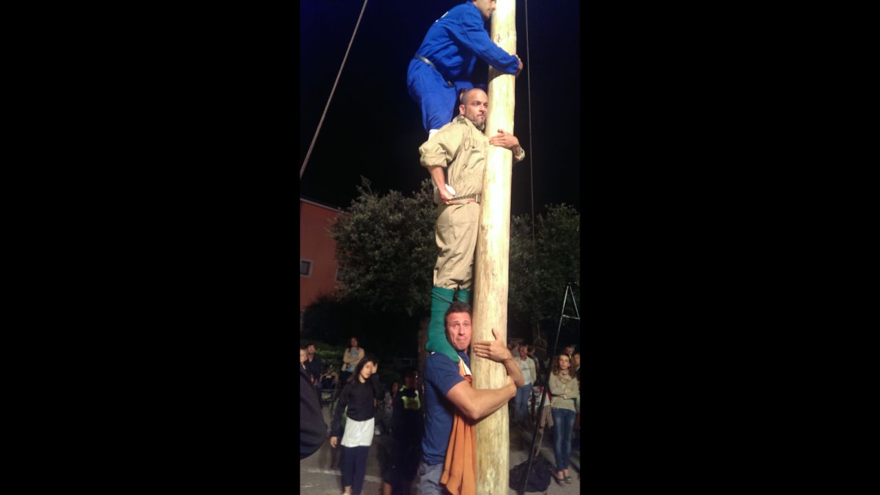 Cuomo is the low man during a practice run for the "Palo" competition. The pole is greased with pig fat. It takes four men stacked on top of one another, and then the top man scampers up the pole to recover various goodies: prosciutto, cash and even cigarettes.