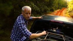 Anderson Cooper in the back of a pick-up truck, driving to an old Cooper family cemetery along the Mississippi-Alabama border.