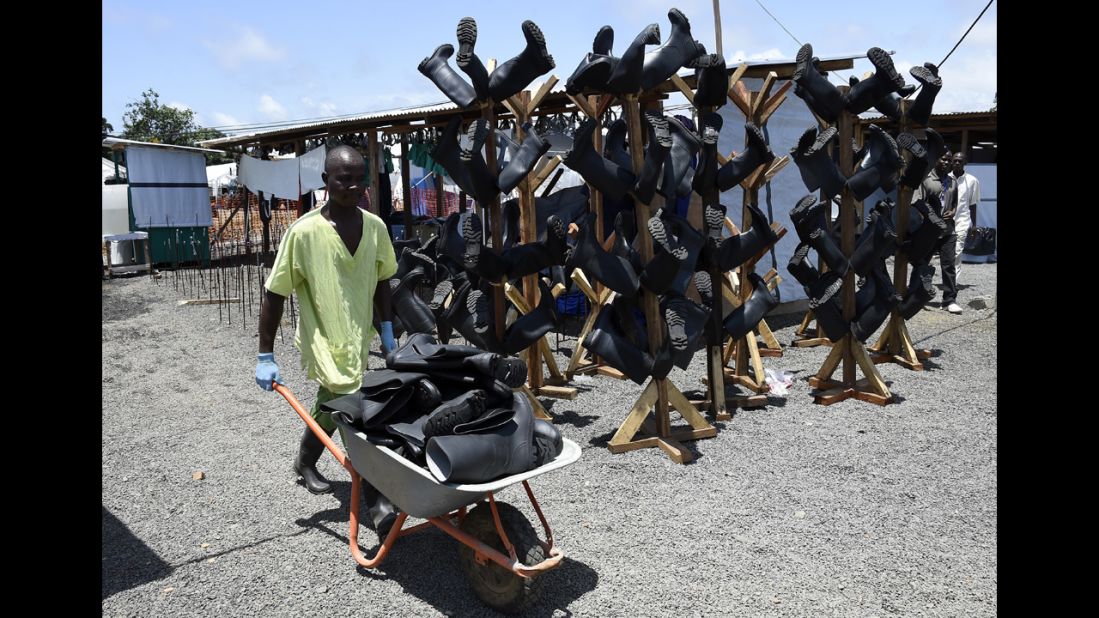 WHO also recommends boots with closed toes, preferably made from rubber. Here, a man carries disinfected boots back to health workers, who will wear them as they treat infected patients. 