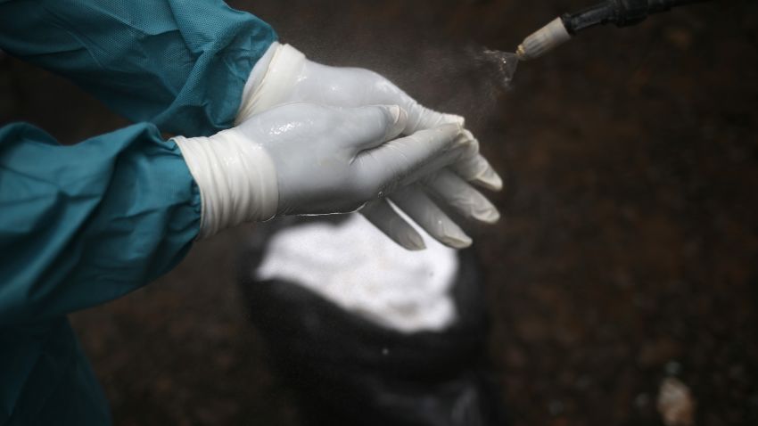 A member of a burial team disinfects his hands after collecting the body of an Ebola victim for cremation on October 2, 2014 in Monrovia, Liberia. Eight Liberian Red Cross burial teams under contract with the country's Ministry of Health collect the bodies of Ebola victims each day in the capital. More than 3,200 people have died in West Africa due to the epidemic. 