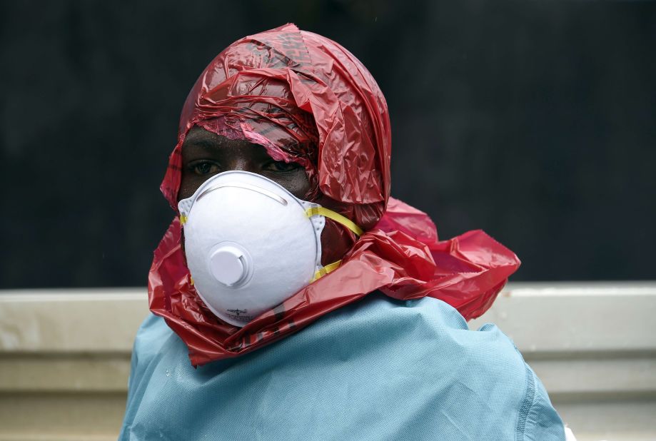 Most people in Ebola-affected areas do not have access to protective suits. Red Cross volunteers have improvised their protective wear and cover their heads with red plastic bags. They cut a hole in the bag to see and breathe.<br />