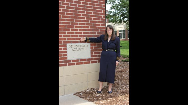 Proud to have accomplished her weight loss goals, Highsmith poses in front of her high school wearing her high school dress.