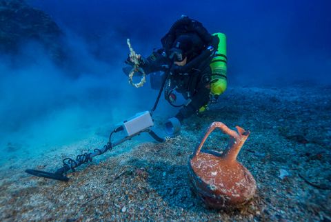 After spending the last month at the historic wreck site, the <a href="http://www.whoi.edu/news-release/antikythera-finds" target="_blank" target="_blank">Woods Hole Oceanographic Institute</a> (WHOI) announced that an international team of archaeologists had recovered new items from the Antikythera wreck. Pictured, Greek technical diver Alexandros Sotiriou discovers an intact "lagynos" ceramic table jug and a bronze rigging ring. The new items have indicated the wreck site is much bigger than previously believed, scattered across 300 meters of seafloor. 