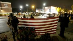 Protesters gather across the street from the Ferguson, Mo., police station holding an inverted American flag in a continuing protest of the shooting of Michael Brown, Friday, Oct. 10, 2014, in Ferguson, Mo. (AP Photo/Charles Rex Arbogast)